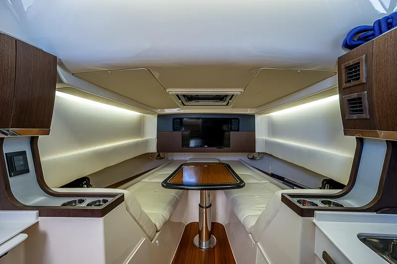  Yacht Photos Pics 2019 Grady-White Canyon 456 cabin interior with seating, table, and TV.