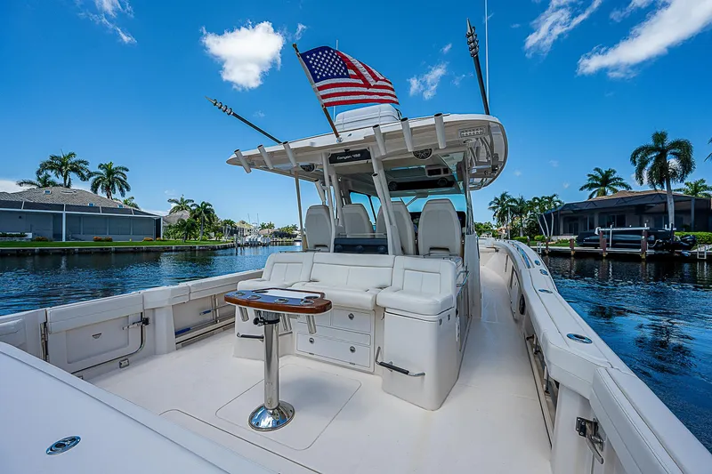  Yacht Photos Pics 2019 Grady-White Canyon 456 boat with American flag, docked in a tropical marina.