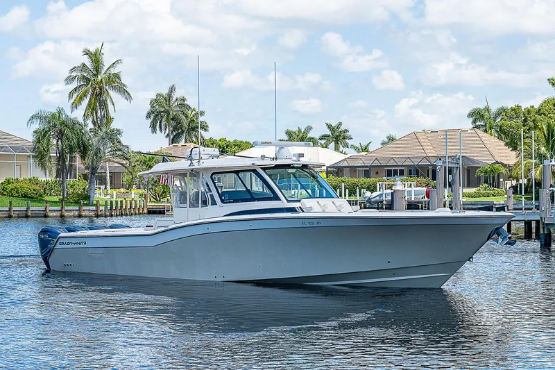  Yacht Photos Pics 2019 Grady-White Canyon 456 boat cruising on a sunny day near waterfront homes.