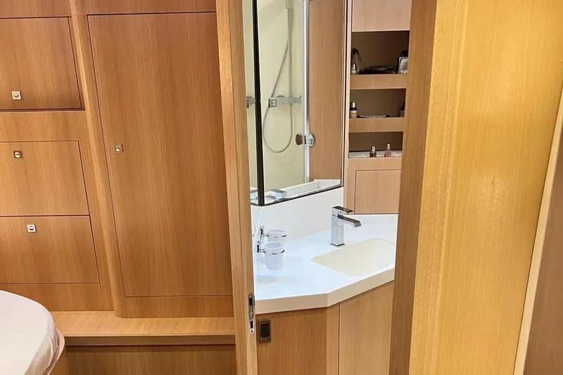  Yacht Photos Pics Luxurious bathroom interior on a 2016 Amel 64 yacht, featuring wooden cabinetry and modern fixtures.