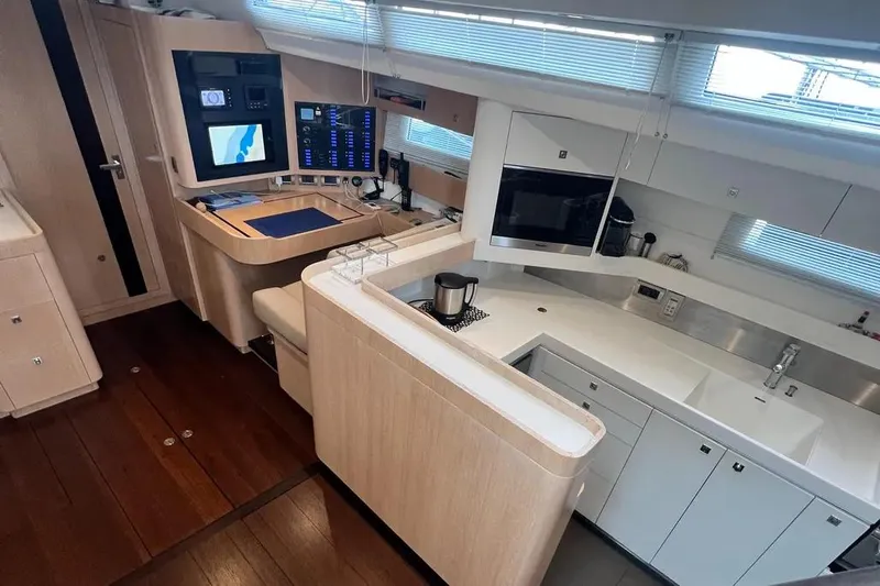  Yacht Photos Pics Modern kitchen and navigation area in 2016 Amel 64 yacht, featuring sleek design and advanced equipment.