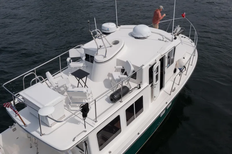 William B Yacht Photos Pics 2003 American Tug 34 on water, featuring spacious deck and seating area.