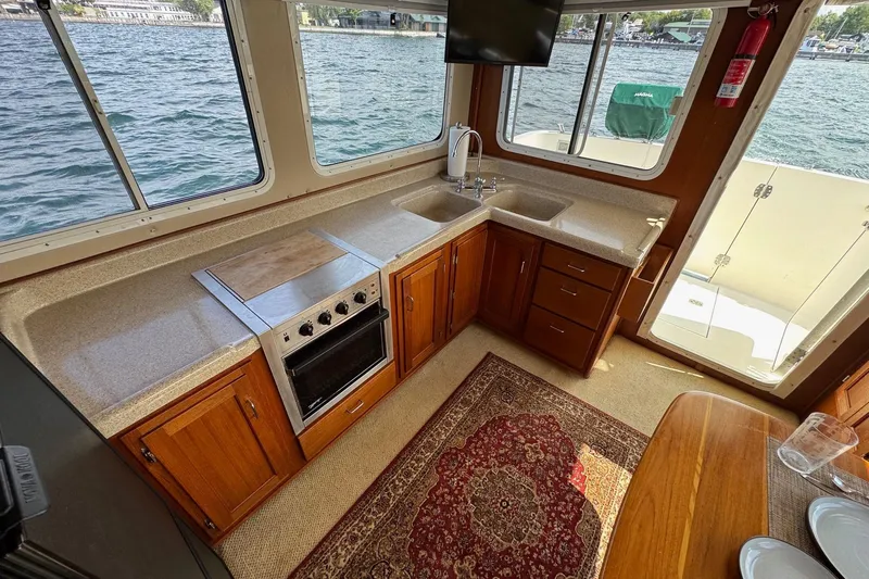 William B Yacht Photos Pics Interior of 2003 American Tug 34, featuring a kitchen with wood cabinets and water views.