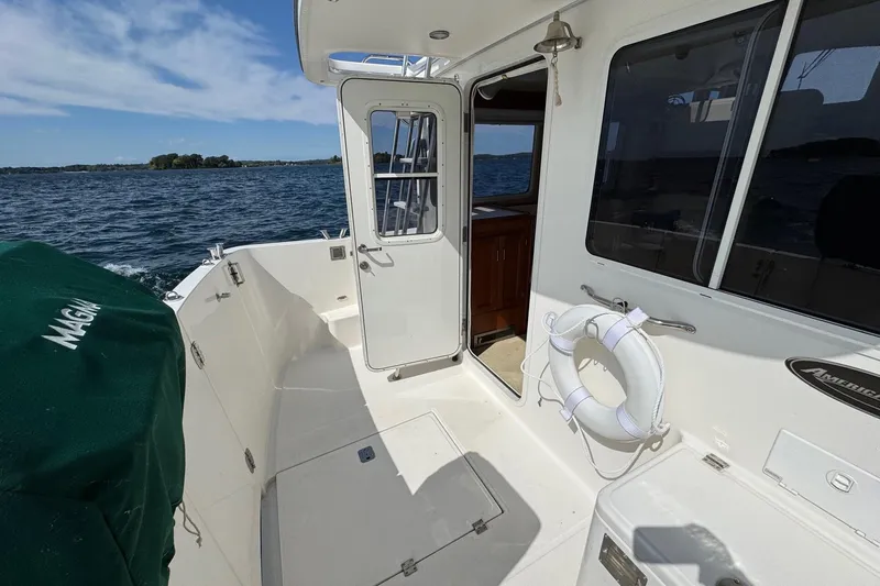 William B Yacht Photos Pics 2003 American Tug 34 boat deck with open cabin door, life preserver, and ocean view.