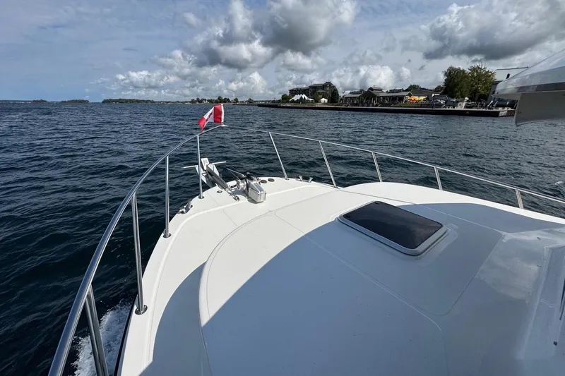 William B Yacht Photos Pics American Tug 34 (2003) cruising on a scenic waterway under a cloudy sky.