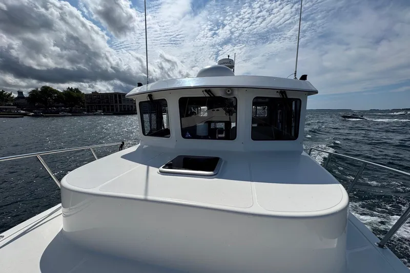 William B Yacht Photos Pics 2003 American Tug 34 cruising on a scenic waterway under a partly cloudy sky.
