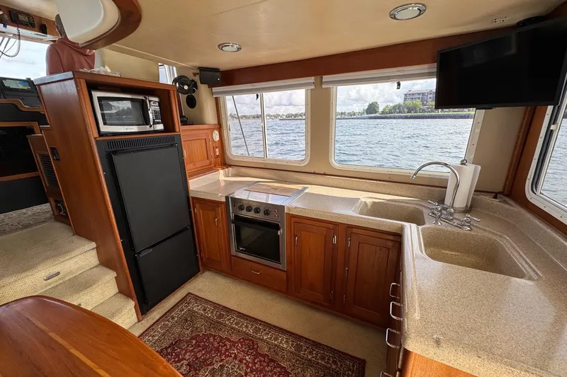 William B Yacht Photos Pics Interior of 2003 American Tug 34, featuring kitchen with appliances and waterfront view.