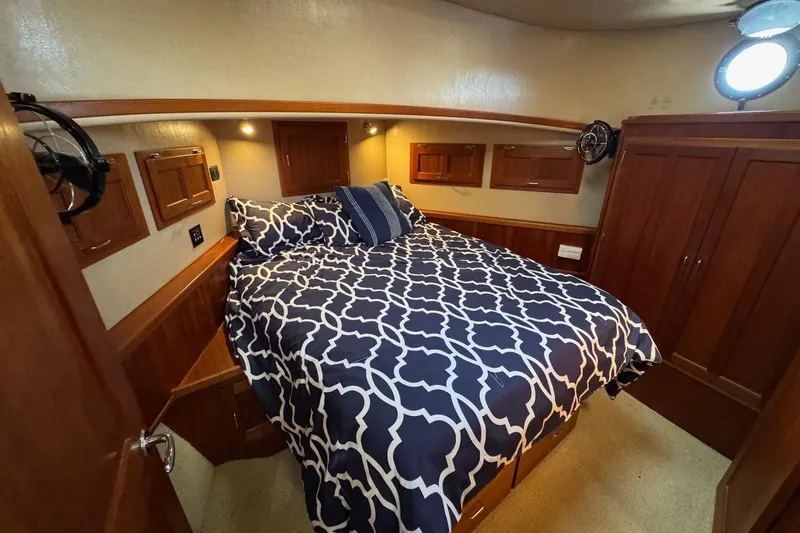 William B Yacht Photos Pics Cozy cabin interior of 2003 American Tug 34 with patterned bedding and wooden cabinetry.
