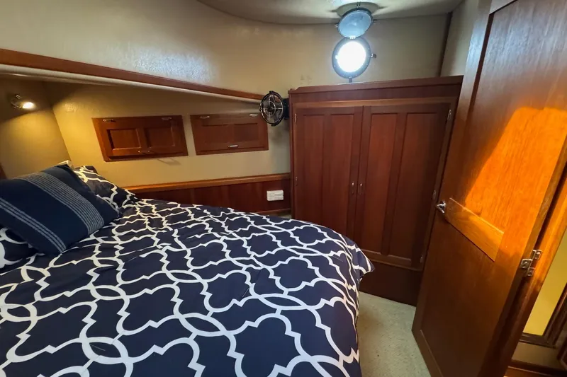 William B Yacht Photos Pics Cozy bedroom in 2003 American Tug 34 with nautical decor and wooden cabinetry.
