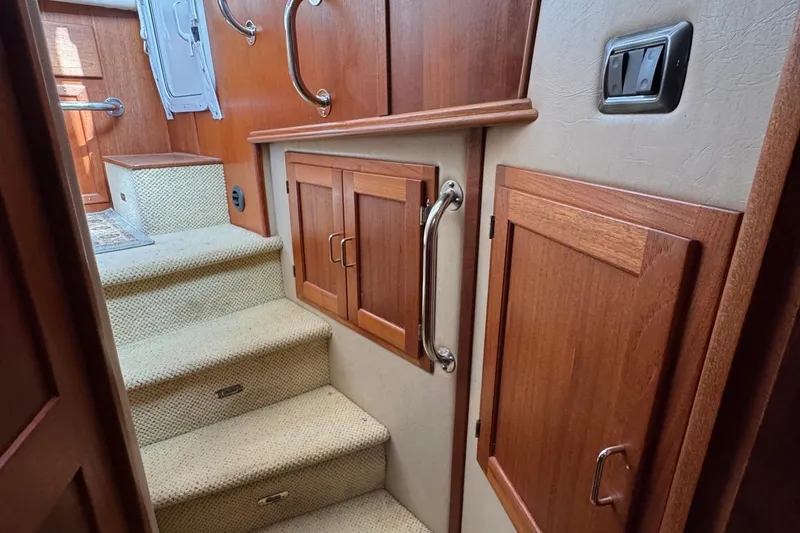 William B Yacht Photos Pics Interior of 2003 American Tug 34, featuring wooden cabinetry and carpeted stairs.