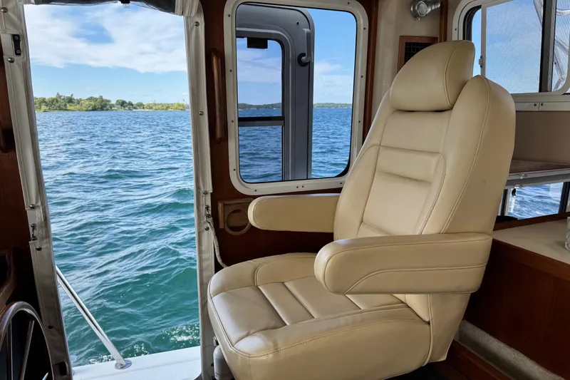 William B Yacht Photos Pics Captain's chair inside a 2003 American Tug 34, overlooking serene waters.
