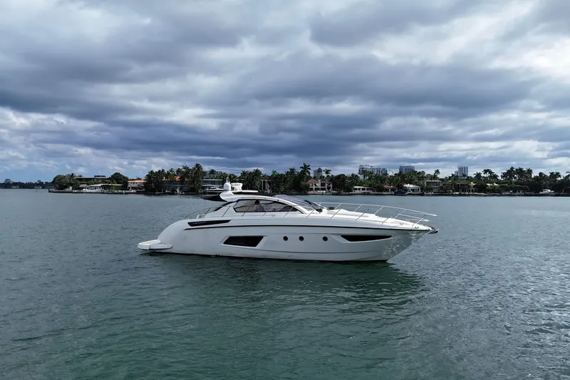 Princessita Yacht Photos Pics Luxurious 2014 Azimut Atlantis yacht cruising on a serene waterway under cloudy skies.