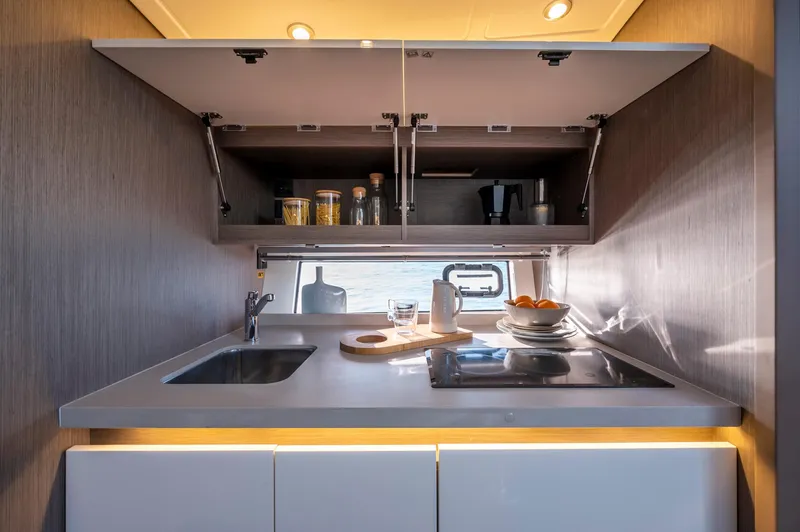 In Stock Yacht Photos Pics Modern kitchen interior of 2023 Beneteau Gran Turismo 41 yacht, featuring sleek cabinetry and appliances.