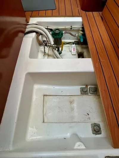 Golden Handcuffs Yacht Photos Pics Beneteau 373 (2007) sailboat interior with open engine compartment and wooden flooring.