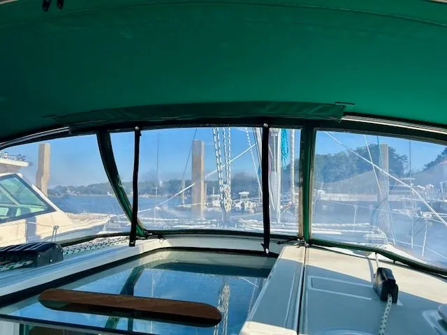 Golden Handcuffs Yacht Photos Pics Interior view of 2007 Beneteau 373 sailboat with green canopy and marina background.