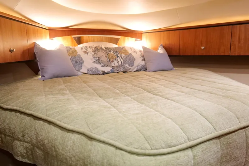 Chico Malo Yacht Photos Pics Luxurious bedroom interior of 2008 Tiara Yachts 4300 Sovran with cozy bedding and ambient lighting.
