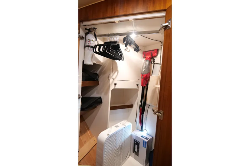 Chico Malo Yacht Photos Pics 2008 Tiara Yachts 4300 Sovran closet with hangers, fire extinguisher, and fan.