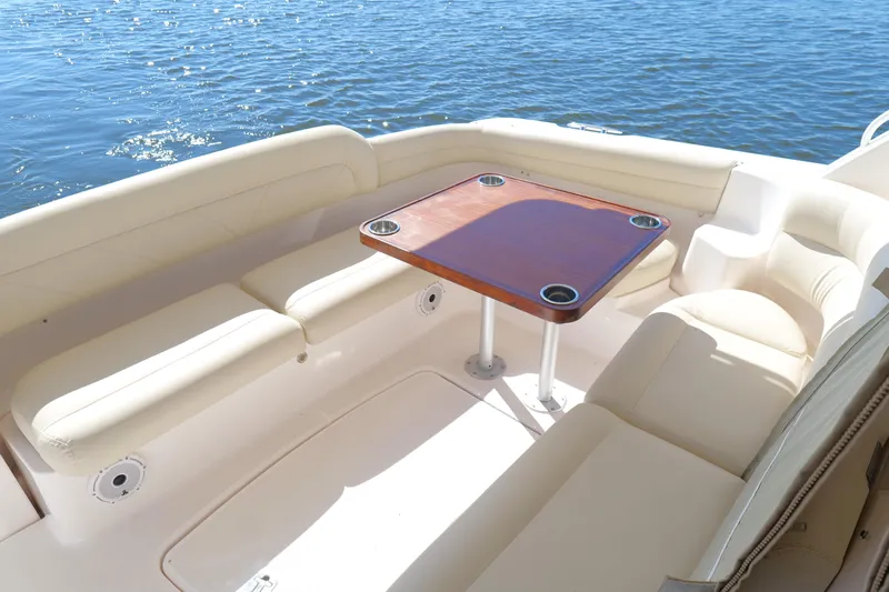 Chico Malo Yacht Photos Pics 2008 Tiara Yachts 4300 Sovran cockpit with cushioned seating and wooden table by the water.