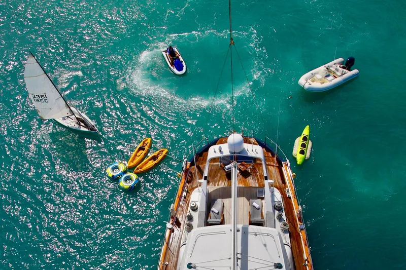 Unplugged Yacht Photos Pics Aerial view of Valdettaro 112 yacht surrounded by kayaks and boats in turquoise water.
