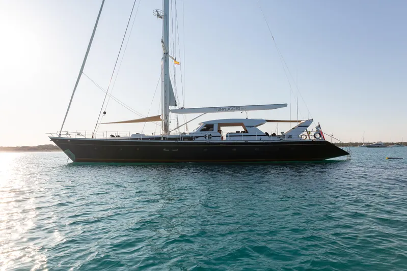 Unplugged Yacht Photos Pics Sailing yacht Valdettaro 112 from 1993 on calm blue waters at sunset.