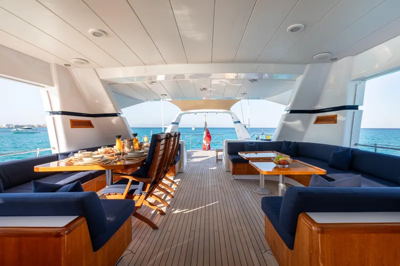 Unplugged Yacht Photos Pics Luxurious 1993 Valdettaro 112 yacht deck with elegant dining setup and ocean view.