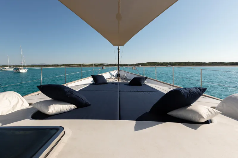Unplugged Yacht Photos Pics Luxurious 1993 Valdettaro 112 yacht deck with cushions, overlooking serene blue waters.
