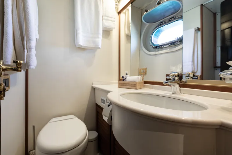Unplugged Yacht Photos Pics Luxurious bathroom in 1993 Valdettaro 112 yacht with elegant fixtures and porthole window.