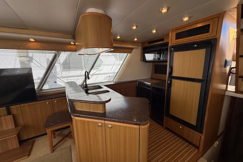  Yacht Photos Pics Interior of 2002 Bayliner 4788 Pilot House Motoryacht with modern kitchen and wood finishes.