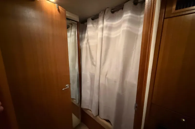  Yacht Photos Pics Interior of 2002 Bayliner 4788 Pilot House Motoryacht with wooden door and curtain.