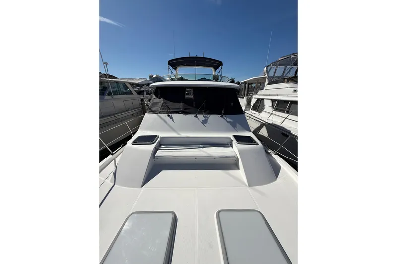  Yacht Photos Pics 2002 Bayliner 4788 Pilot House Motoryacht docked under clear blue sky.