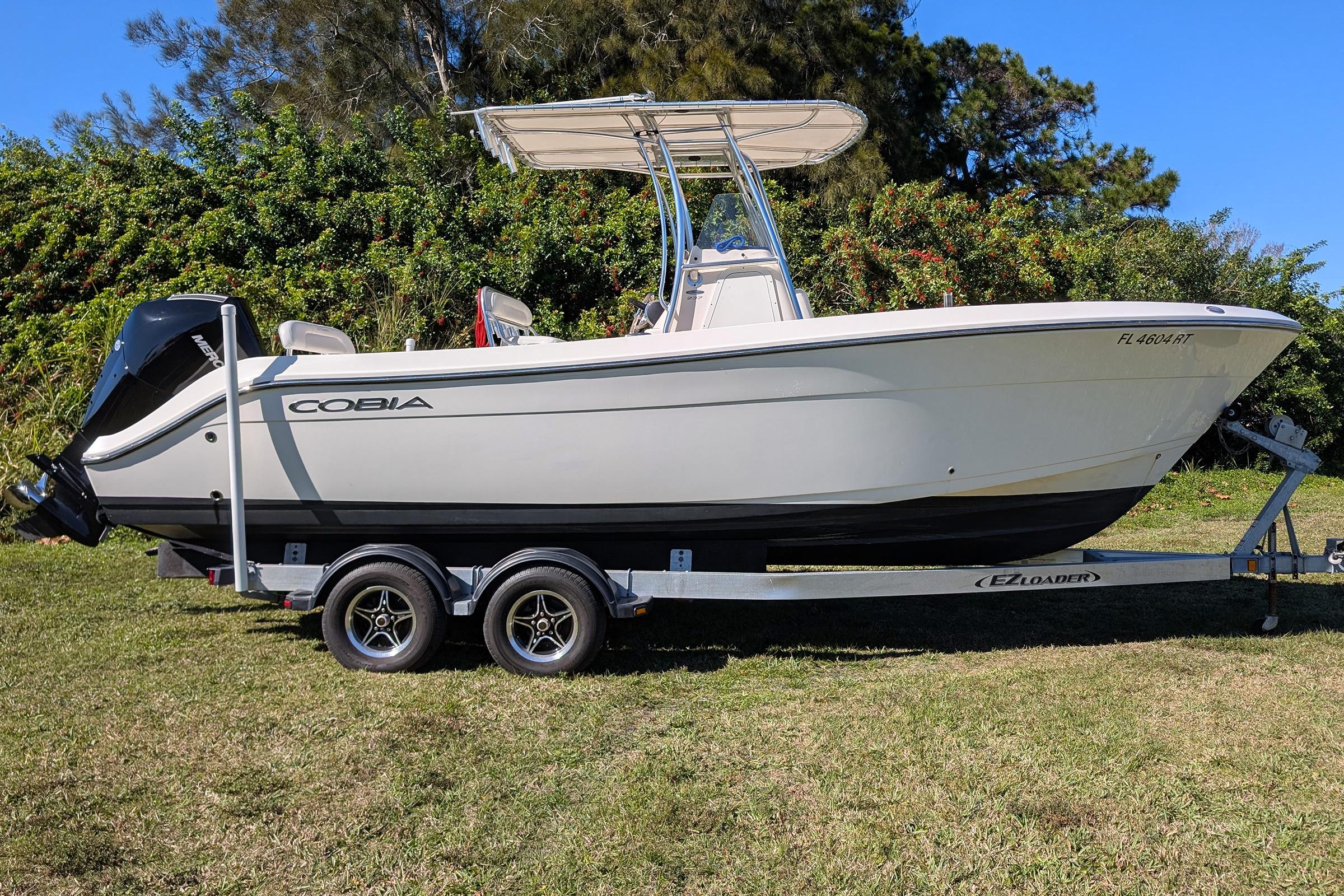2019 Cobia 237 Center Console boat on trailer, parked on grass.