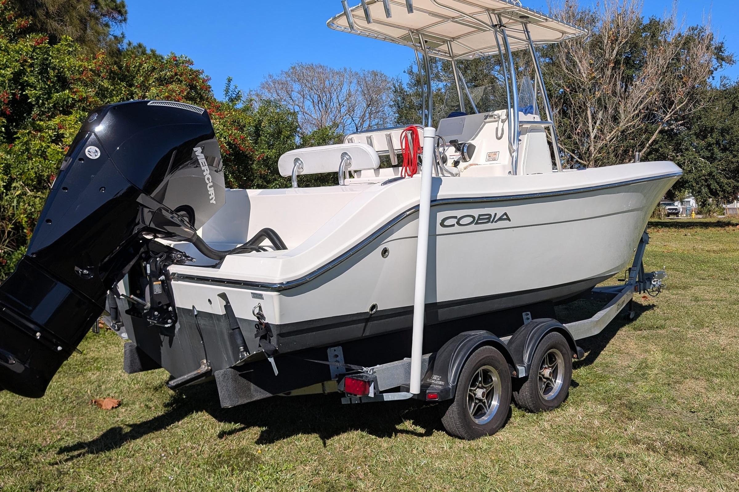 2019 Cobia 237 Center Console boat on trailer, featuring Mercury outboard motor.