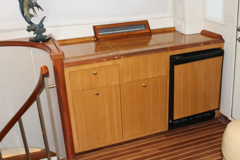 Killin Time Yacht Photos Pics 2003 Viking 65 Convertible Enclosed Bridge interior with wooden cabinetry and mini fridge.