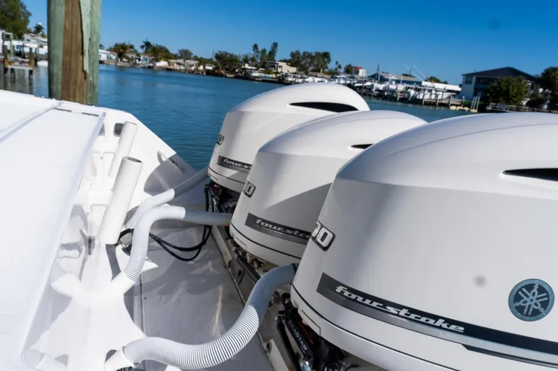 Yacht Photos Pics Triple outboard engines on a 2013 Jupiter 34 FS boat docked by the water.