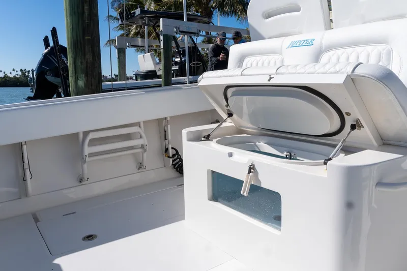  Yacht Photos Pics 2013 Jupiter 34 FS boat interior with open storage compartment, docked by the water.