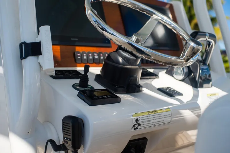  Yacht Photos Pics Control panel of a 2013 Jupiter 34 FS boat with steering wheel and navigation equipment.