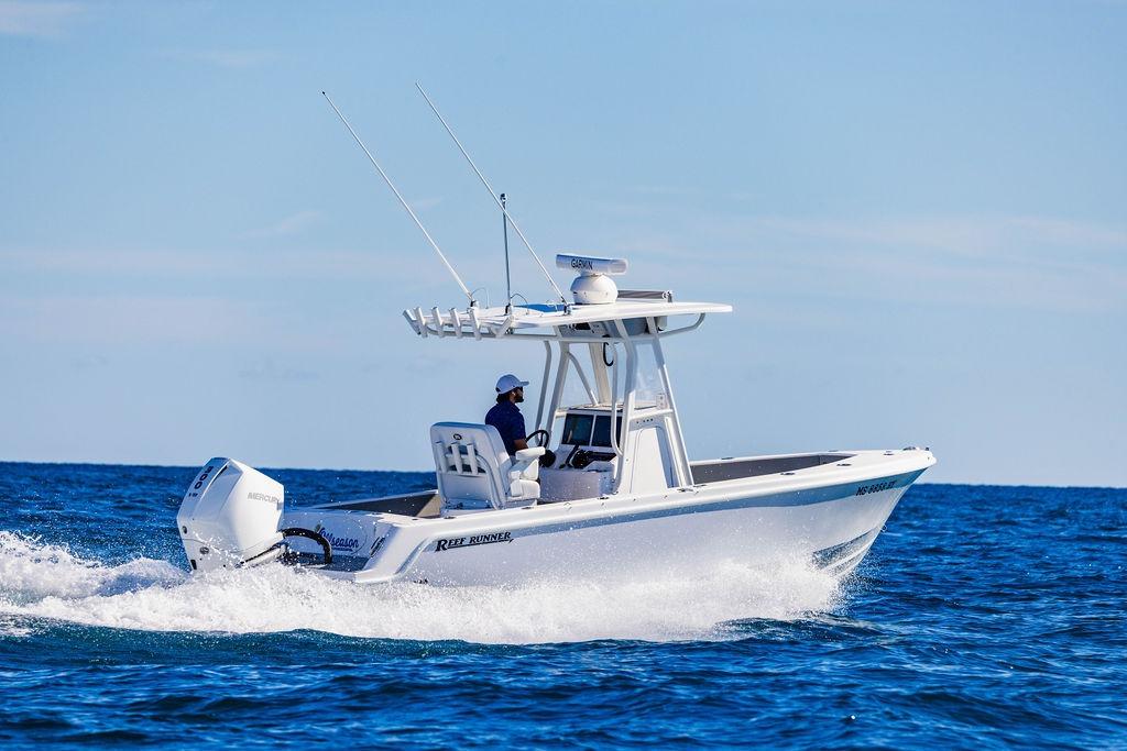 2024 Reef Runner 230 Open boat cruising on the ocean with clear blue skies.