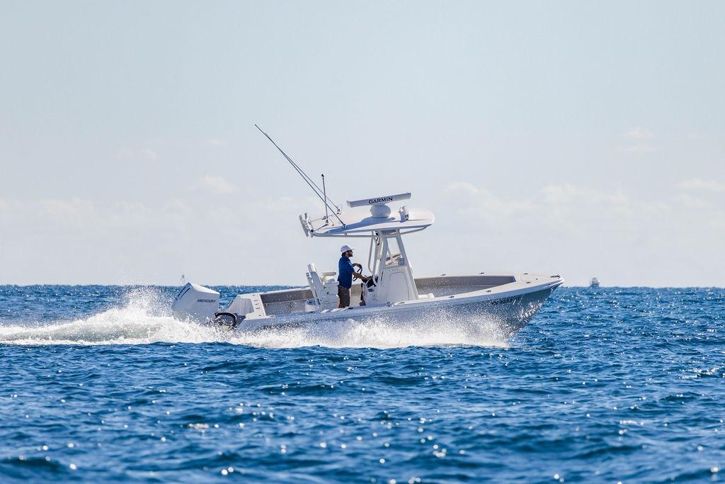 2024 Reef Runner 230 Open boat cruising on ocean waves.