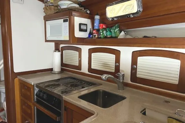 Daisy IV Yacht Photos Pics 2001 Little Harbor WhisperJet 44 yacht kitchen with stove, sink, and storage cabinets.