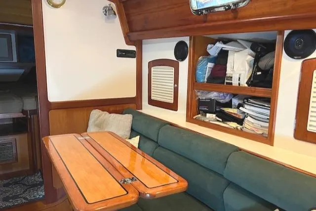 Daisy IV Yacht Photos Pics Interior of 2001 Little Harbor WhisperJet 44 with wooden table and green seating.