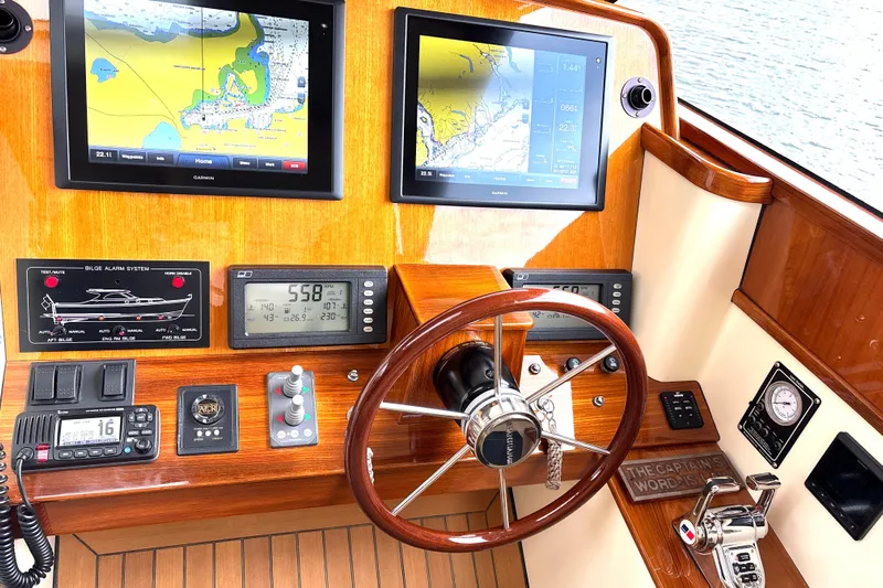 Flight Yacht Photos Pics 2009 San Juan 48 yacht helm with navigation screens and wooden steering wheel.