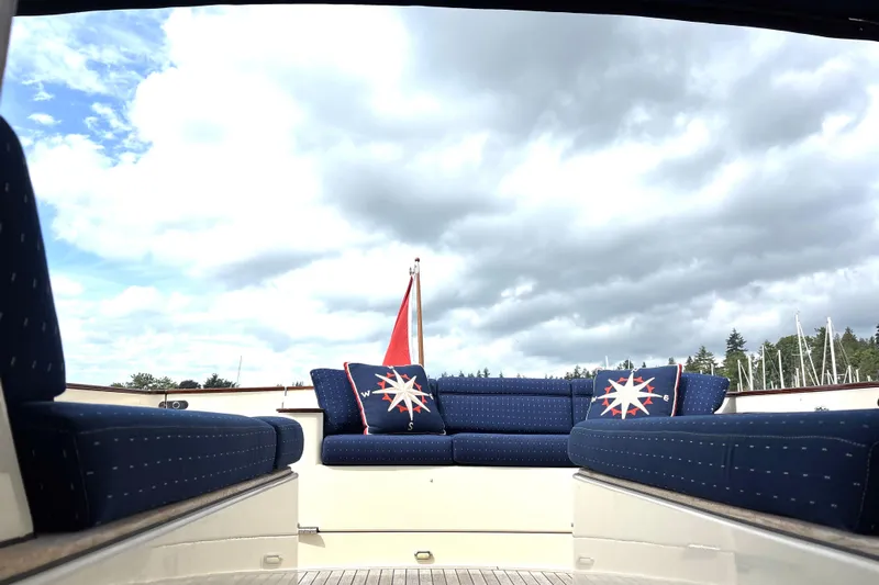 Flight Yacht Photos Pics Luxurious 2009 San Juan 48 yacht with blue seating and nautical-themed cushions under cloudy sky.