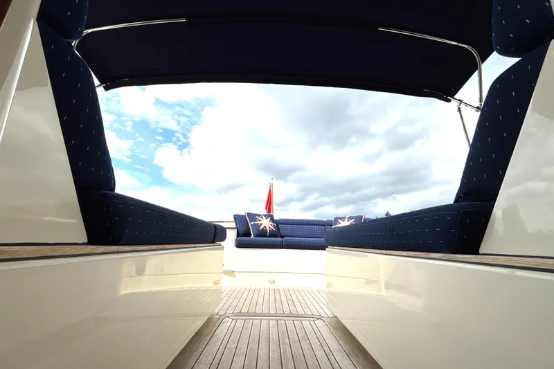 Flight Yacht Photos Pics 2009 San Juan 48 yacht interior with blue seating and wooden deck under cloudy sky.