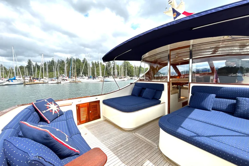 Flight Yacht Photos Pics Luxurious 2009 San Juan 48 yacht with blue seating, docked in a scenic marina.