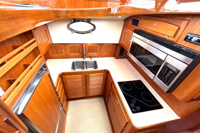 Flight Yacht Photos Pics Luxurious 2009 San Juan 48 yacht kitchen with wood cabinetry, modern appliances, and dual sink.