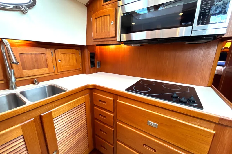 Flight Yacht Photos Pics Luxurious 2009 San Juan 48 yacht kitchen with wooden cabinetry and modern appliances.