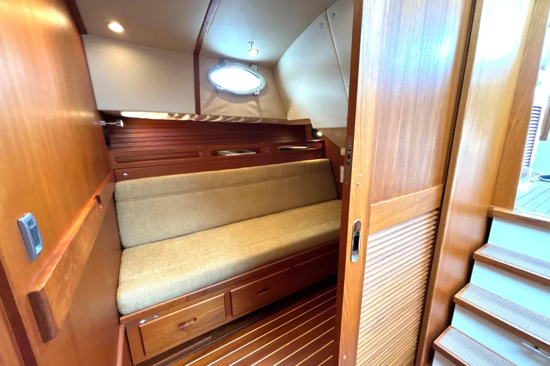 Flight Yacht Photos Pics Cozy cabin interior of 2009 San Juan 48 yacht with wooden finishes and cushioned seating.