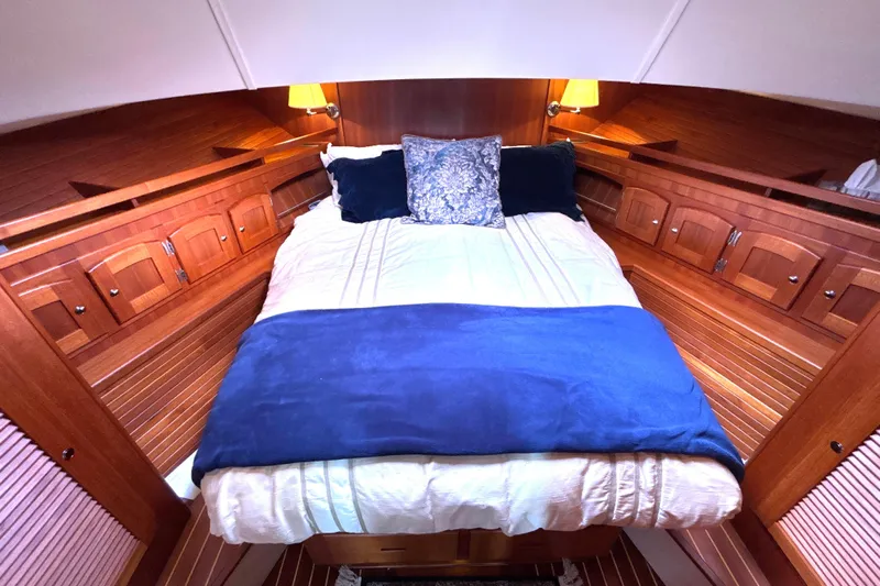 Flight Yacht Photos Pics Luxurious cabin interior of 2009 San Juan 48 yacht with cozy bedding and wooden finish.