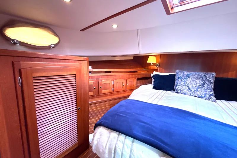 Flight Yacht Photos Pics Luxurious cabin interior of 2009 San Juan 48 yacht with wooden finishes and cozy bedding.