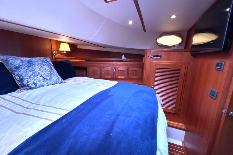 Flight Yacht Photos Pics Luxurious cabin interior of 2009 San Juan 48 yacht with cozy bedding and wooden finishes.